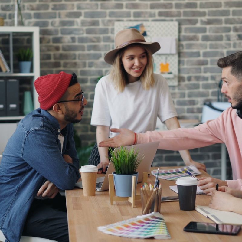 Group of young professionals brainstorming ideas in a modern office environment.